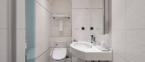 A modern bathroom with a toilet, sink, and mirror.