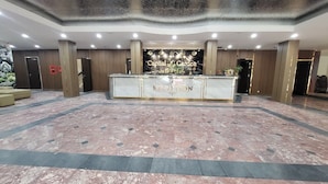 A reception area with a marble floor, a reception desk, and a sign that reads "Capital Garden Hotel." - Capital Garden Hotel (Hanoi)