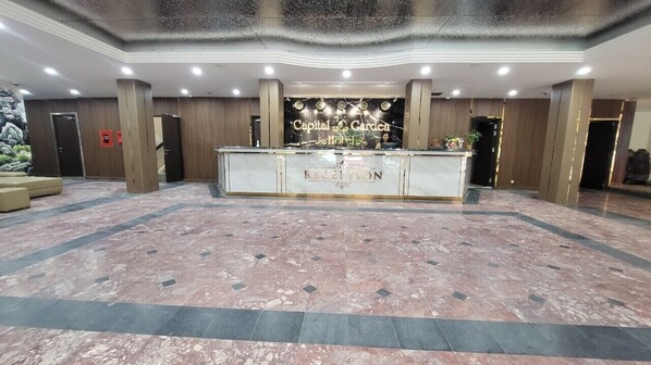 A reception area with a marble floor, a reception desk, and a sign that reads "Capital Garden Hotel." - Capital Garden Hotel (Hanoi)