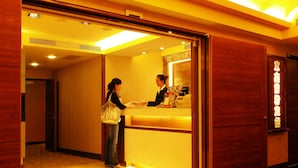 A reception area with a wooden interior, a reception desk, and a sign with Japanese characters. - Eastern Star Hotel (Taipei)