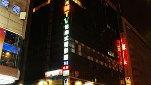 A building with illuminated signage, including a prominent 'MTV' sign, and various storefronts at street level. - Eastern Star Hotel (Taipei)