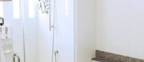 A bathroom with a shower, a toilet, and a sink.