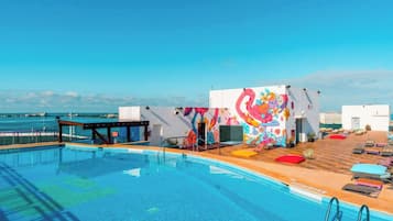 Una piscina al aire libre, sillones reclinables de piscina