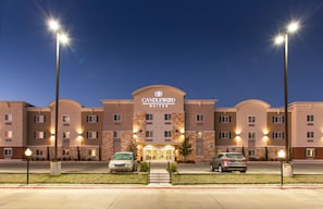 Un hotel con una entrada destacada, varios pisos y una fachada bien iluminada.
