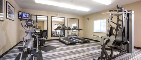 A fitness center with treadmills, elliptical machines, and weight equipment.