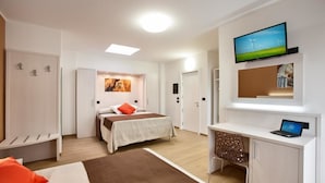 A modern hotel room with a bed, desk, TV, and artwork. - Bed & Breakfast Aria di Mare (Gallipoli)