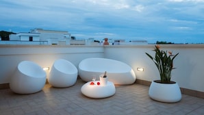 A rooftop terrace with modern seating and a potted plant. - Bed & Breakfast Aria di Mare (Gallipoli)
