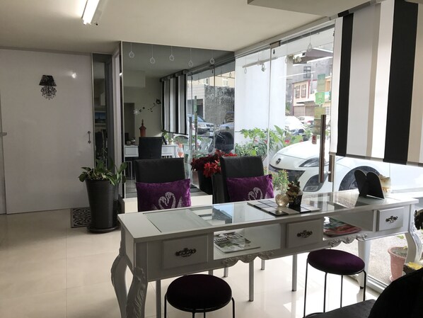 Un comedor moderno con una mesa de vidrio, sillas negras y un mueble blanco.