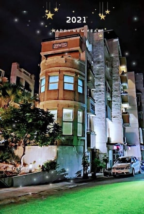 A modern building with multiple floors, large windows, and a well-lit facade.