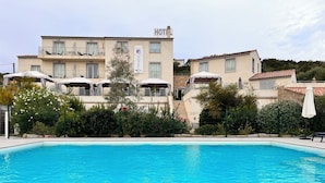 A hotel with a swimming pool, multiple balconies, and a sign indicating it is a hotel. - Casa Murina Hôtel Demeure Ecologique (Serra-di-Ferro)