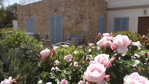 A stone building with shutters, a reception area, and outdoor seating. - Casa Murina Hôtel Demeure Ecologique (Serra-di-Ferro)
