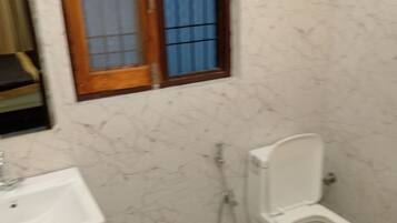 Baño con lavabo, inodoro y ducha.
