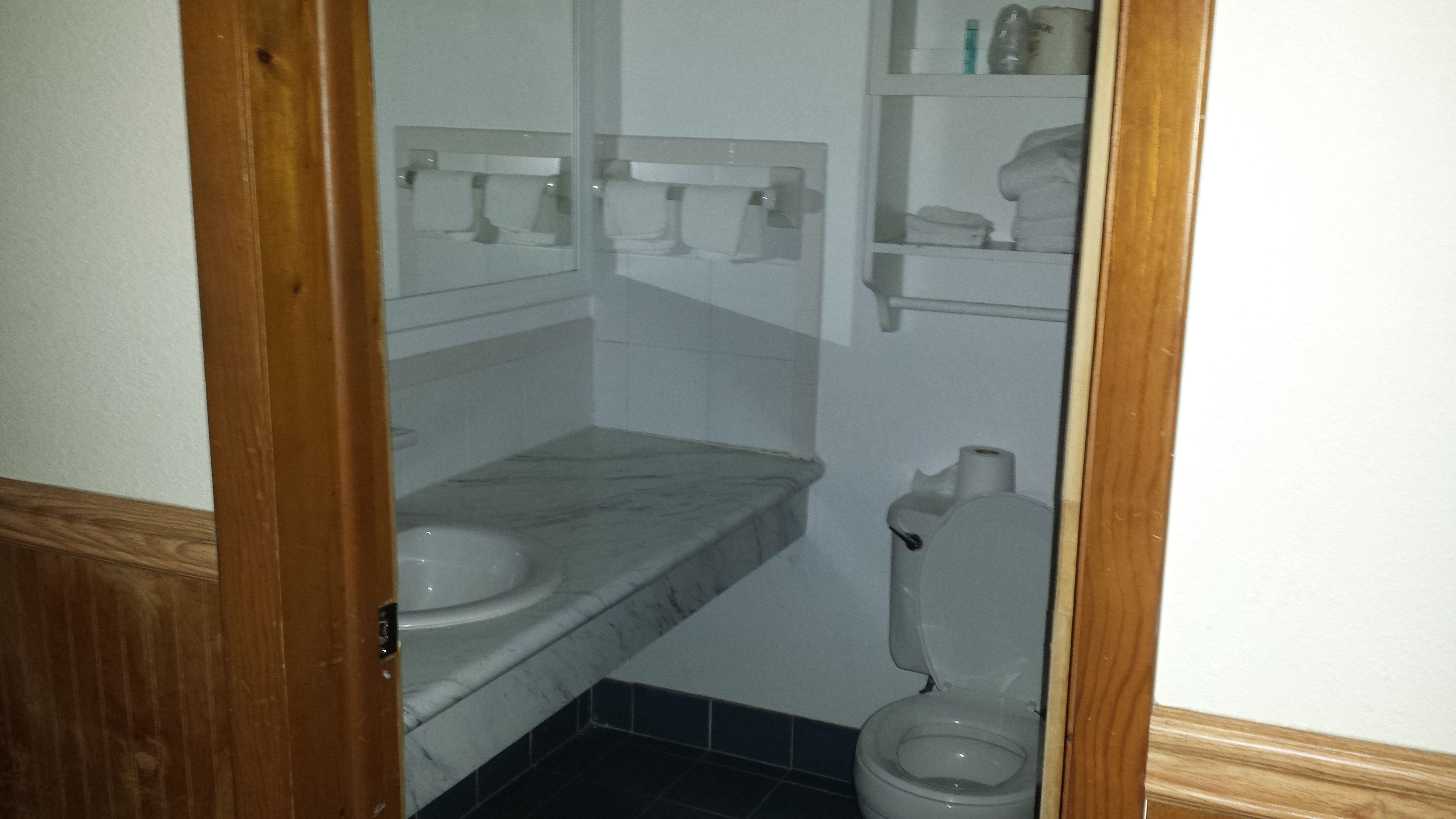 Un baño pequeño con inodoro, lavamanos y espejo.