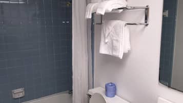 A bathroom with a shower, a toilet, and a towel rack.