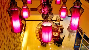 A lobby with multiple hanging pink lamps, a staircase, and a seating area with chairs and tables. - El Cielito Hotel - Sta. Rosa (Santa Rosa)