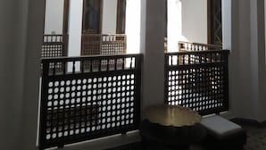 An interior with arched windows, a wooden bench, and a hanging light fixture. - Riad Arous Chamel (Tangier)