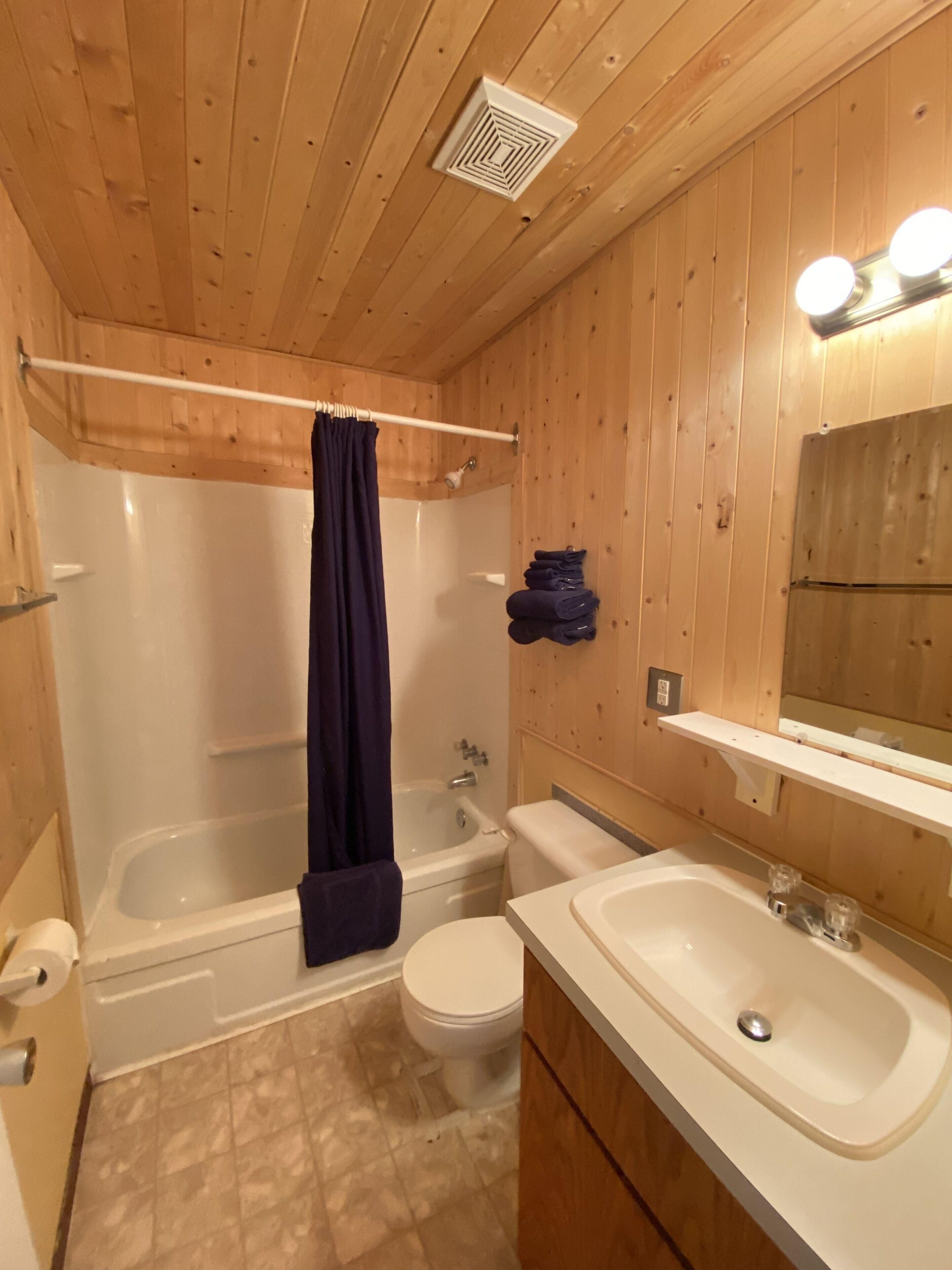 A bathroom with a bathtub, toilet, and sink.