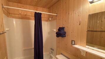 A bathroom with a bathtub, toilet, and sink.