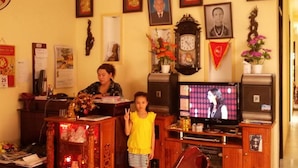 Una sala de estar con televisor, muebles de madera y varias fotos enmarcadas en la pared.