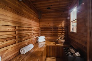 L’intérieur d’une cabane en bois, avec des bancs et une fenêtre.