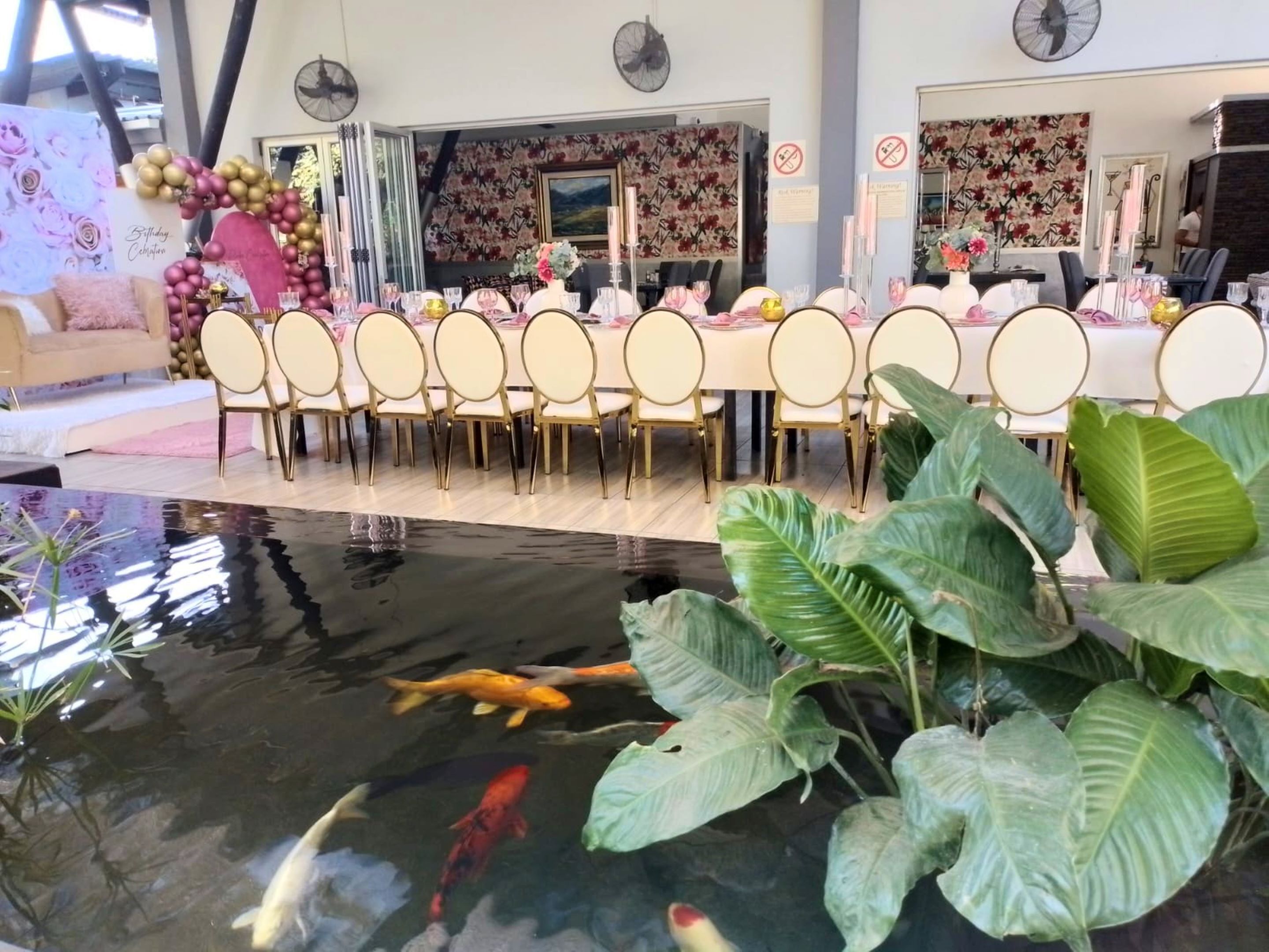 A dining area with a long table set for a meal, surrounded by chairs.