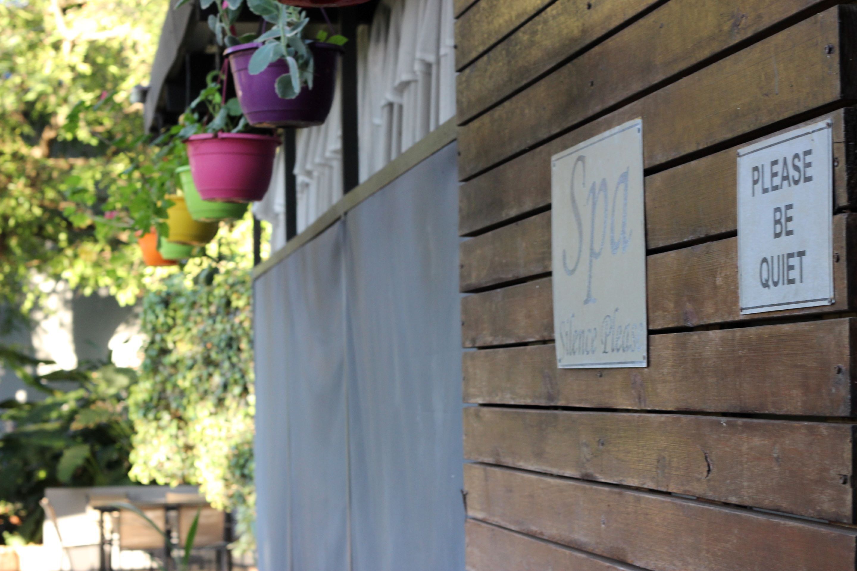 A wooden wall with a spa sign and a 'Please be quiet' sign.
