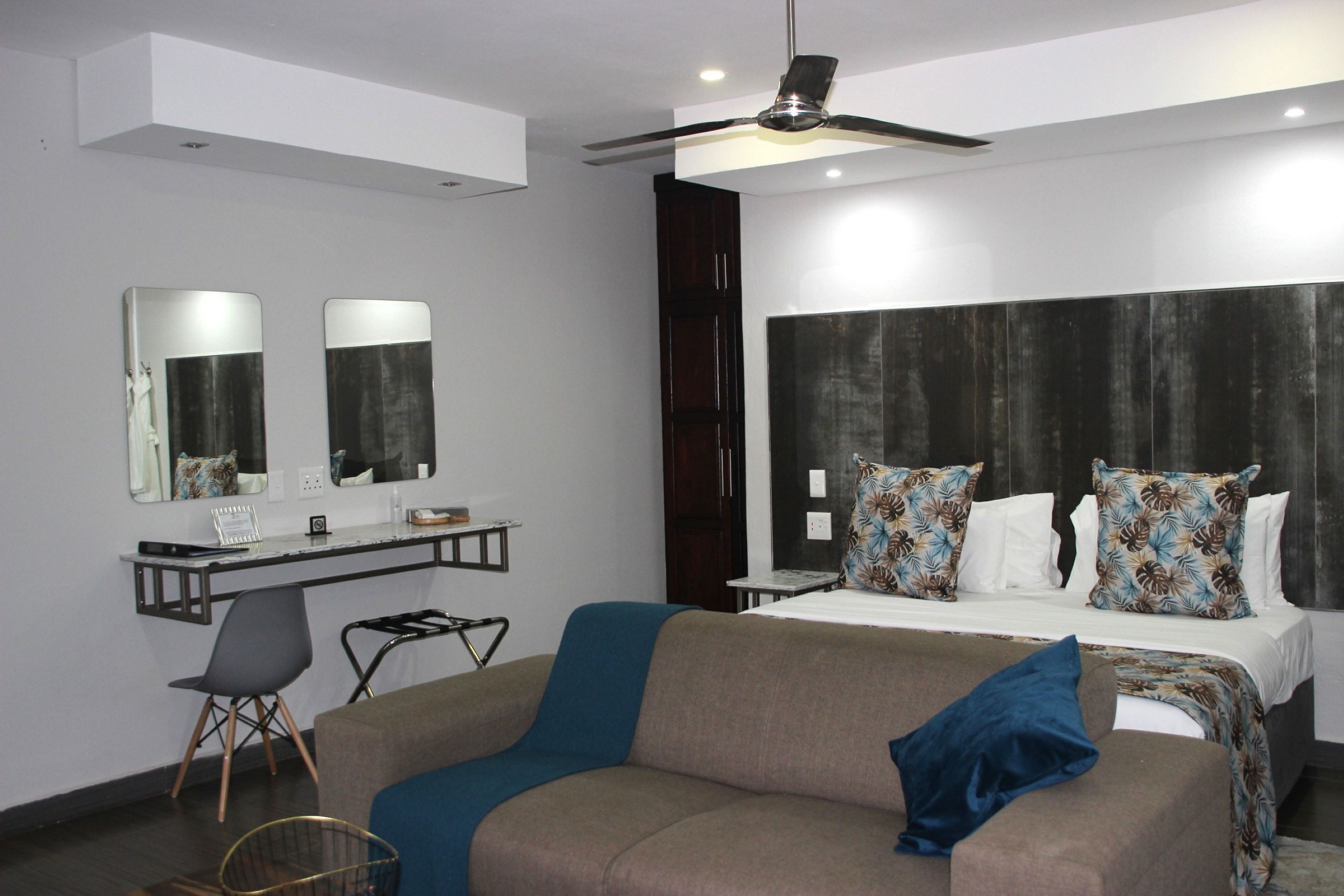 Una habitación de hotel moderna con una cama, un escritorio y una silla.