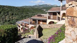 A stone building with multiple balconies and a stone pathway leading to the entrance. - Residence Costa Ruja (Olbia)