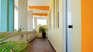 A corridor with a tiled floor, a potted plant, and a door with the number 3.
