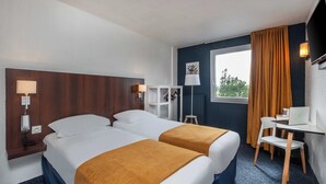 A hotel room with two beds, a desk, a chair, a TV, and a window with curtains. - The originals Hotel Ariane, Toulouse (Toulouse)