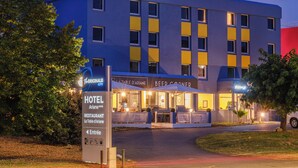 A hotel with a modern design, featuring a prominent entrance and outdoor seating area. - The originals Hotel Ariane, Toulouse (Toulouse)