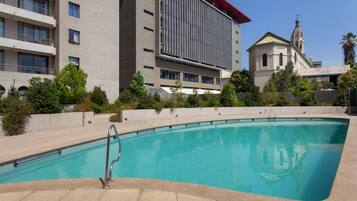 Una piscina al aire libre de temporada, sombrillas