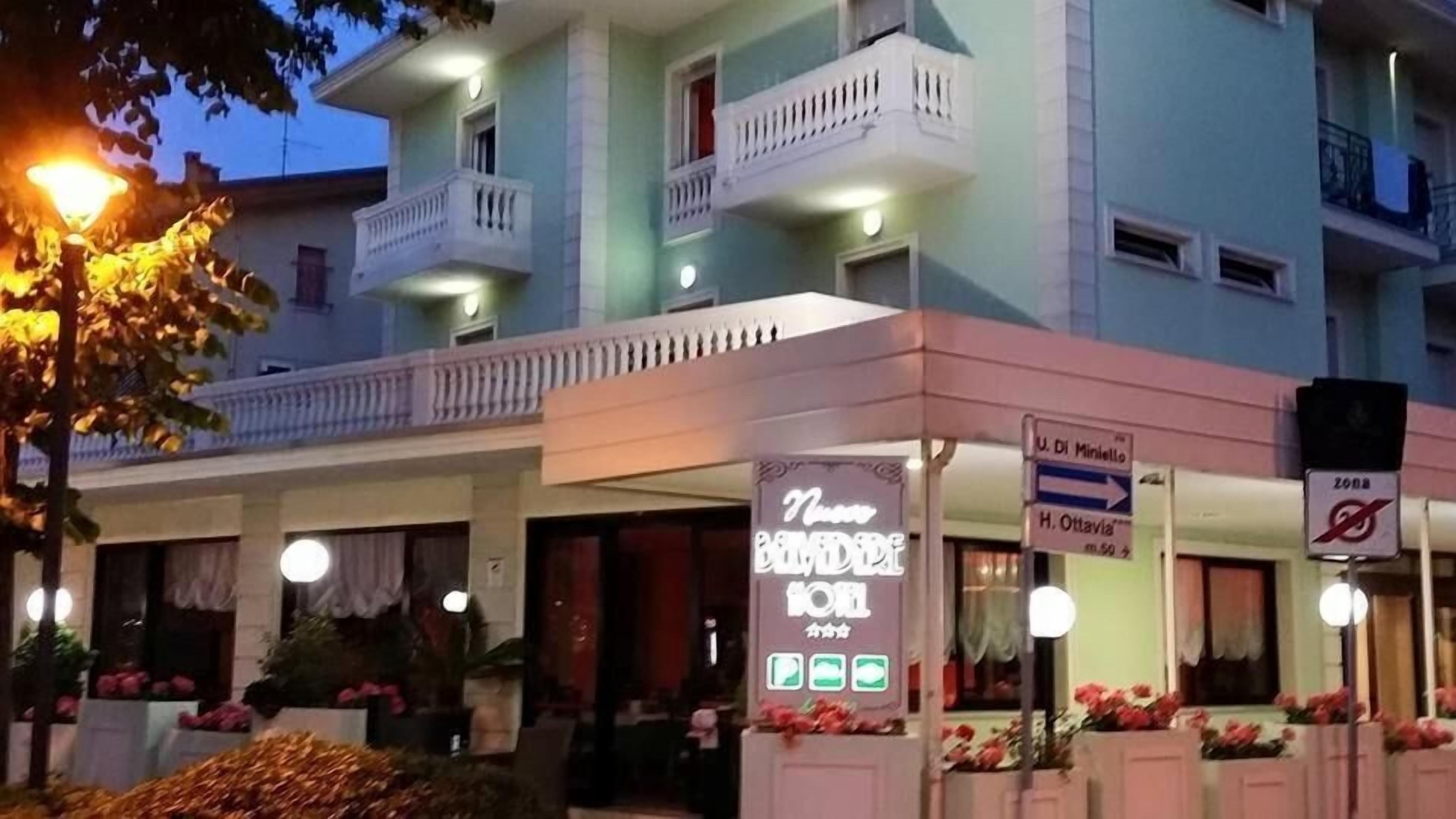 A hotel with a signboard for 'Nino Bardi' and directional signs for 'U. Di Miniello' and 'H. Ottavia'.