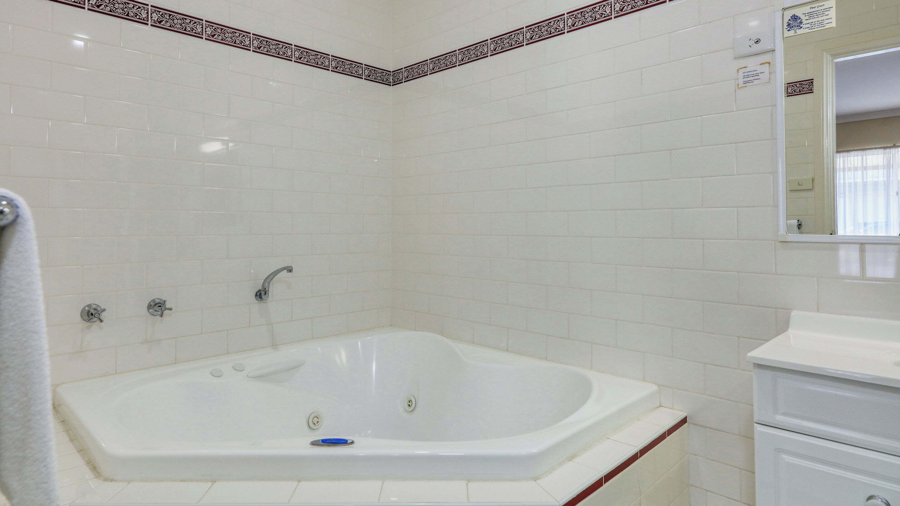 A bathroom with a white bathtub, a sink, and a mirror.