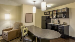 A compact kitchen with a dining area, including a sofa, chairs, and a table.