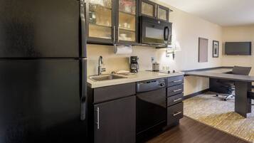 A modern kitchen with a refrigerator, stove, microwave, and sink.
