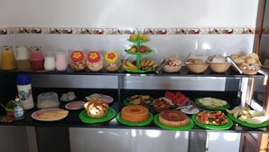 Un bufé con diversos alimentos, incluyendo frutas, pan y postres.