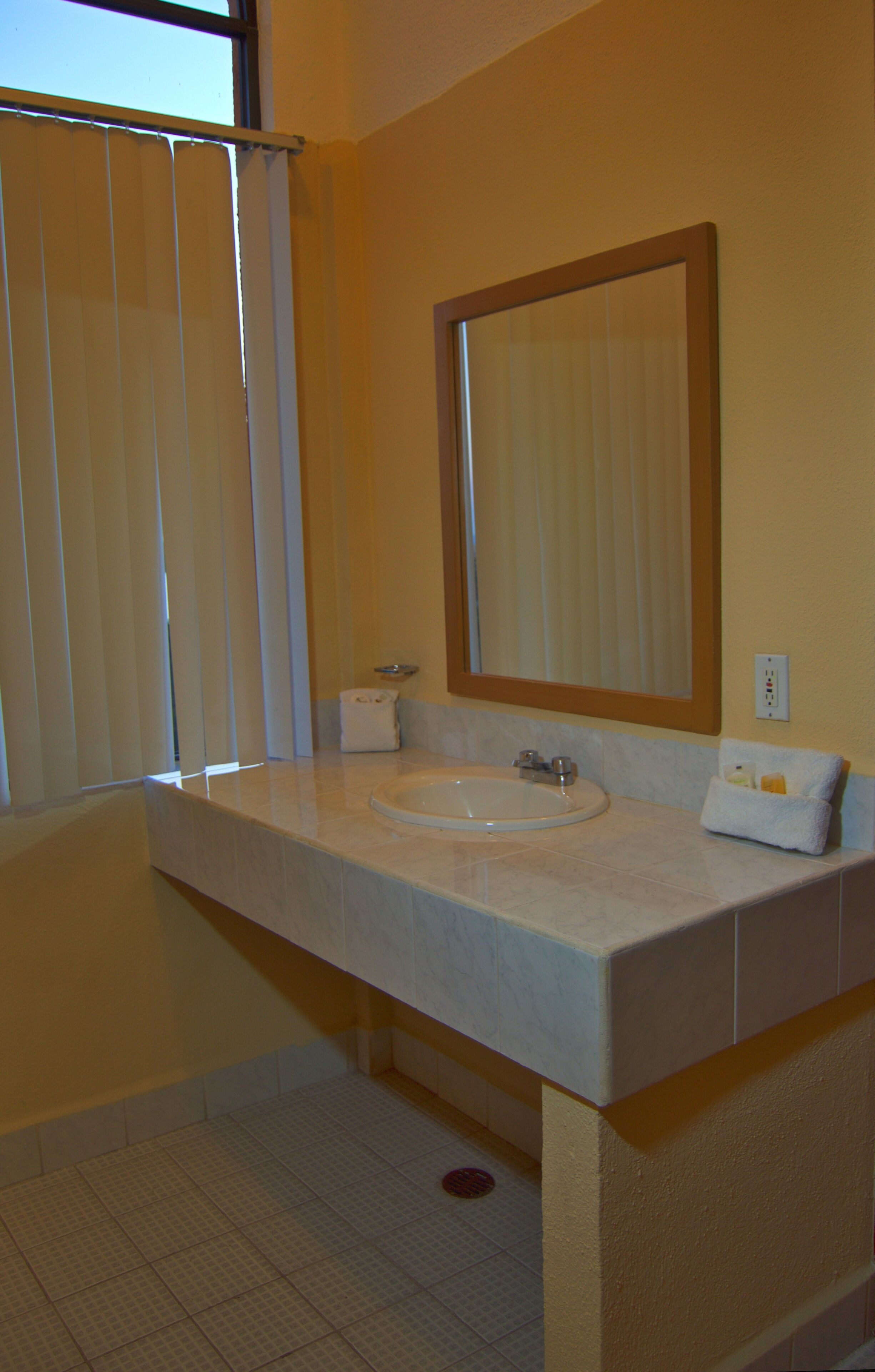 A bathroom with a white sink, a large mirror, and a towel rack.