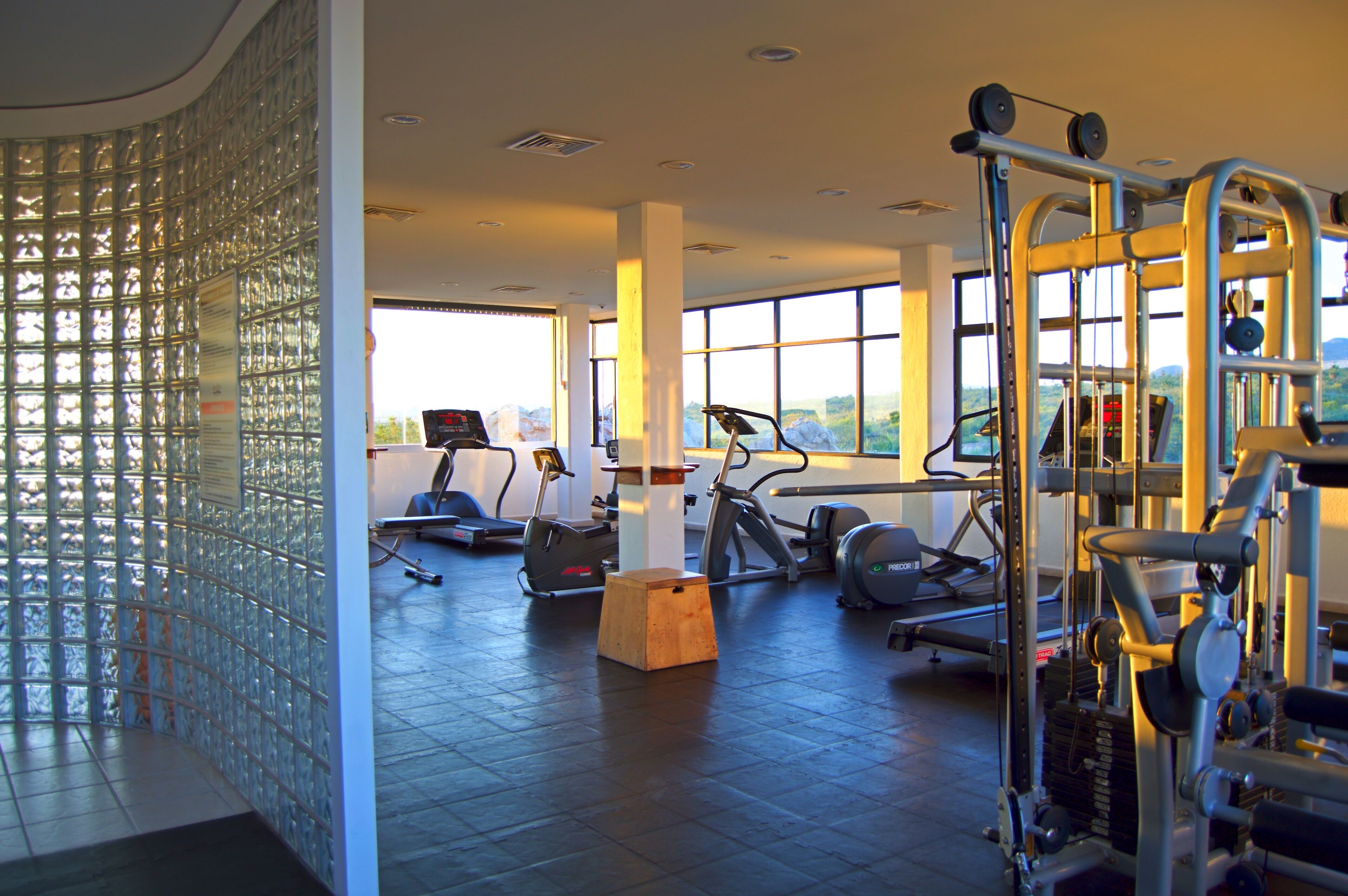 Uma academia com esteiras, elípticos e equipamentos de musculação.