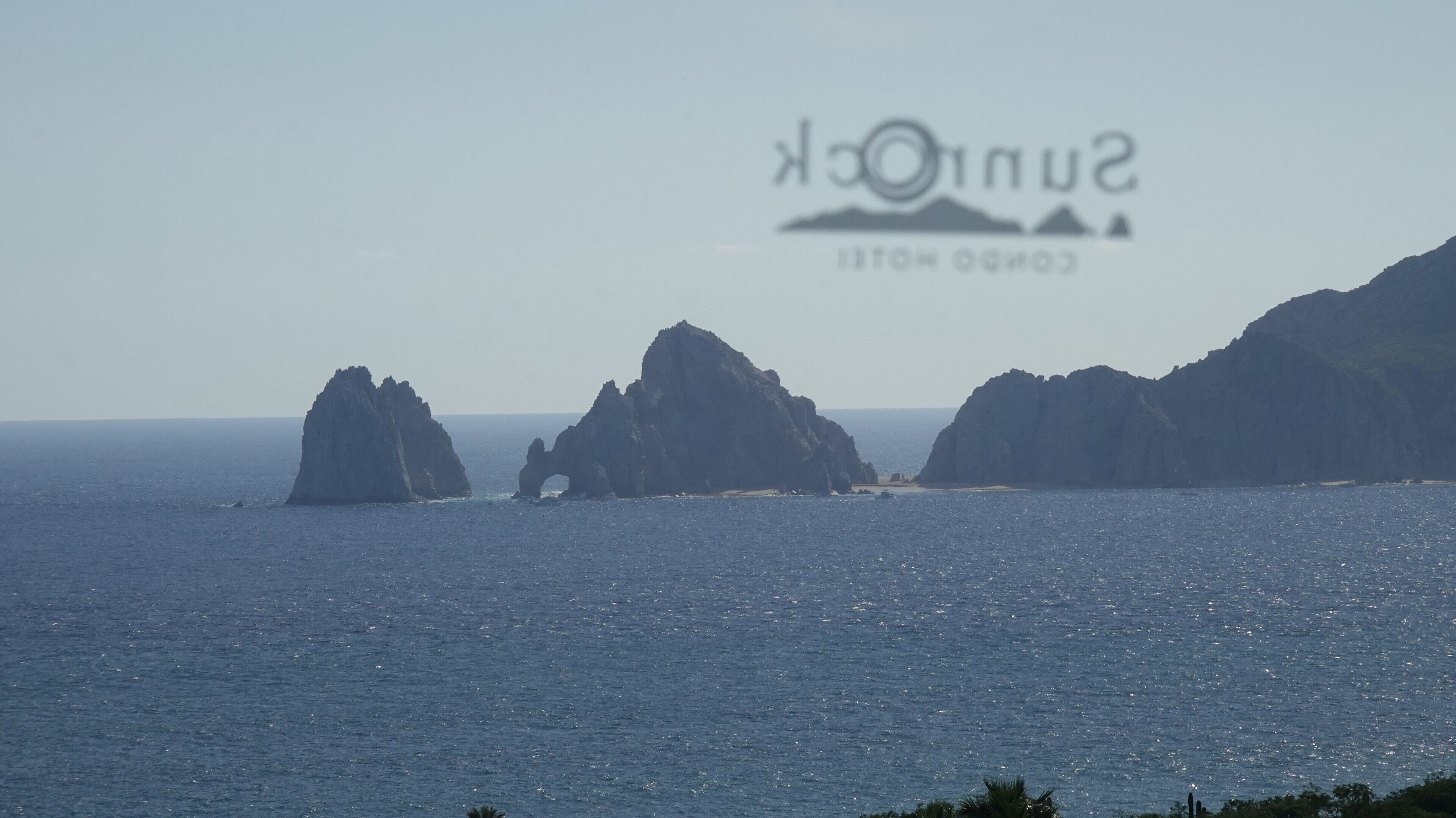 Un paisaje costero con formaciones rocosas y mar tranquilo.
