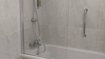 Une cabine de douche moderne dotée d’une porte en verre, d’un pommeau de douche à main et d’un autre pommeau de douche à main.