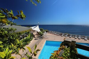 Una piscina al aire libre de temporada, sillones reclinables de piscina