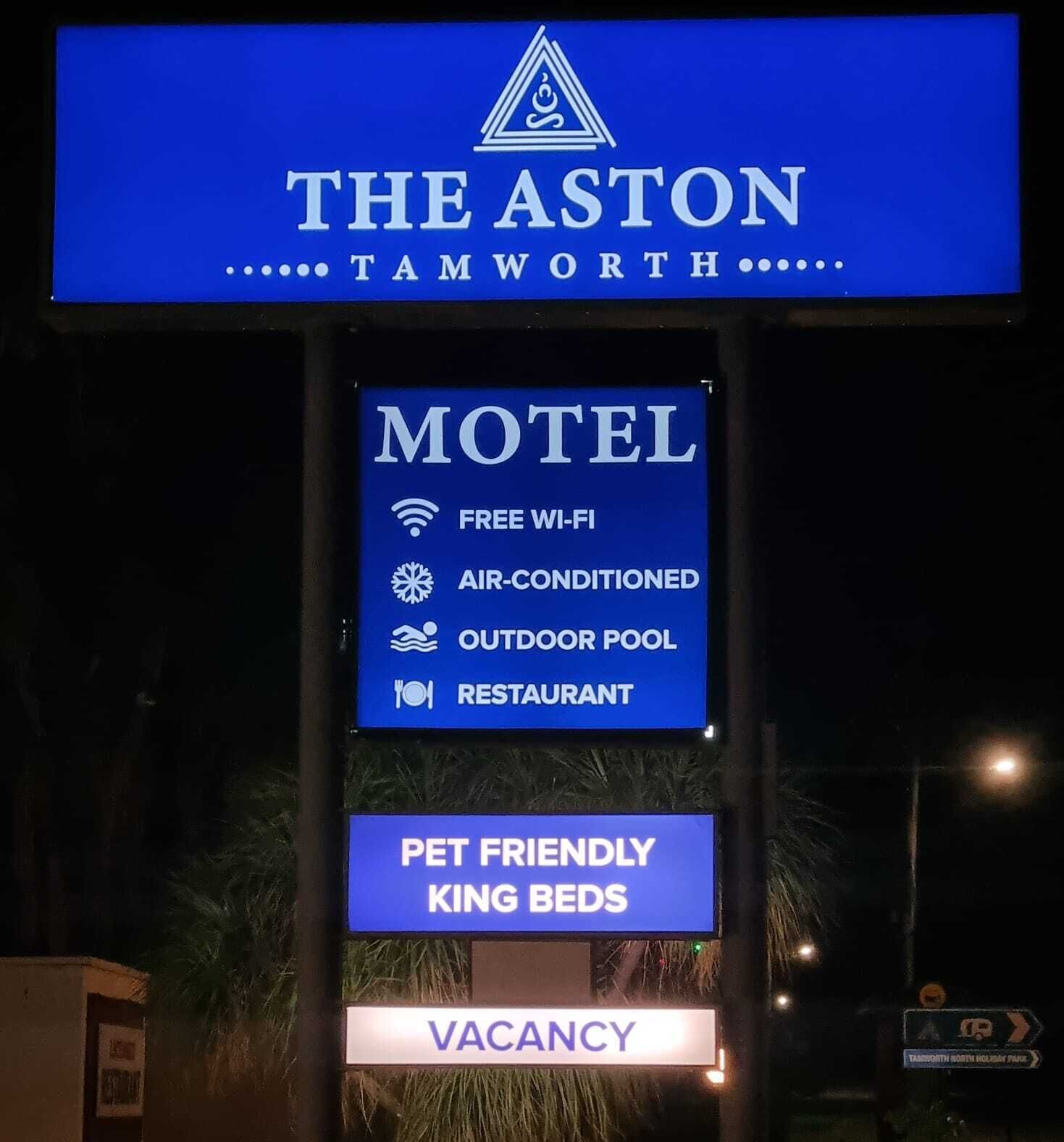 A motel sign with amenities including free Wi-Fi, air conditioning, an outdoor pool, and a restaurant. It also mentions pet-friendly accommodations and king beds.