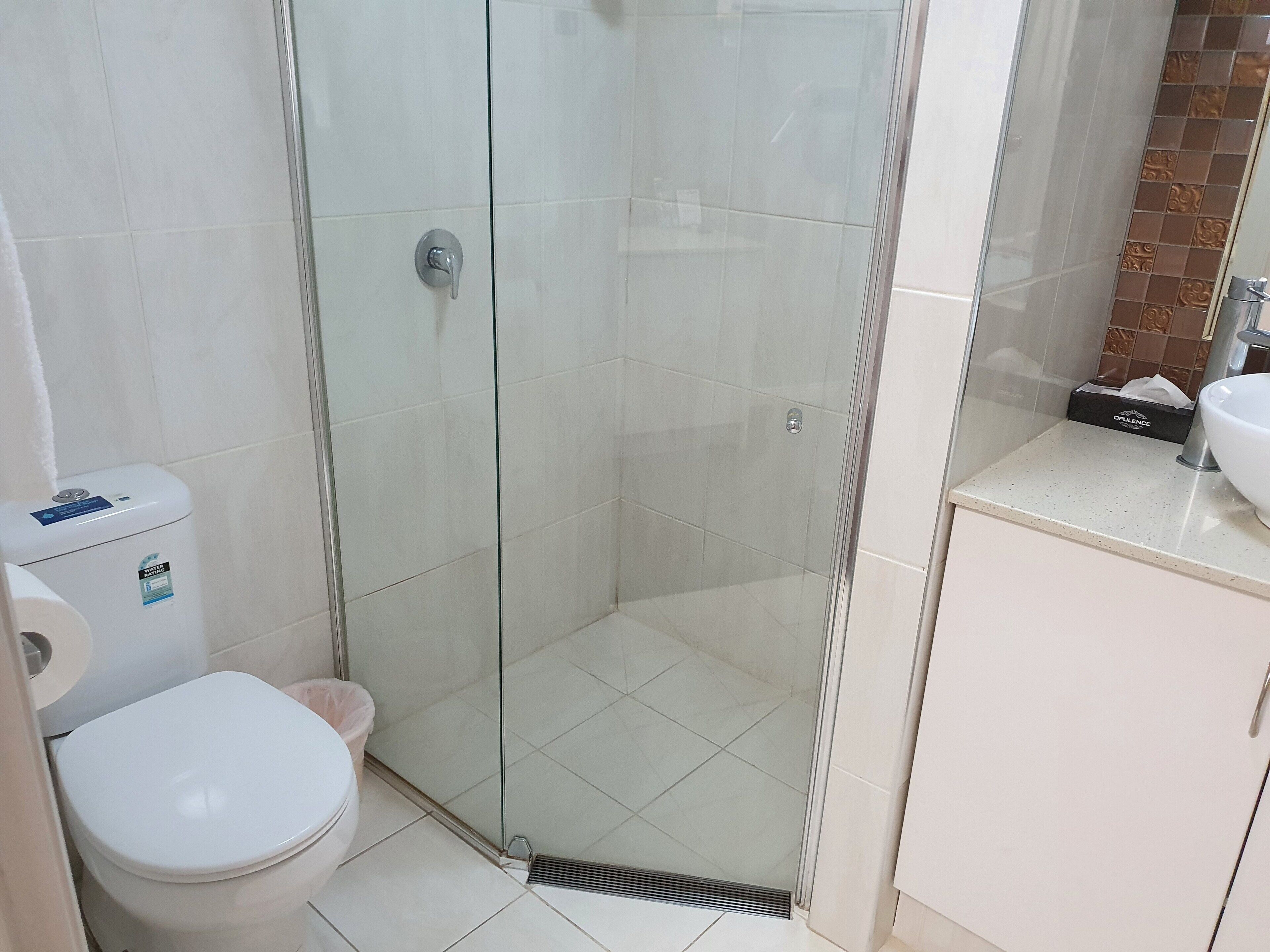 Ein Badezimmer mit Duschkabine, Toilette und Waschbecken.