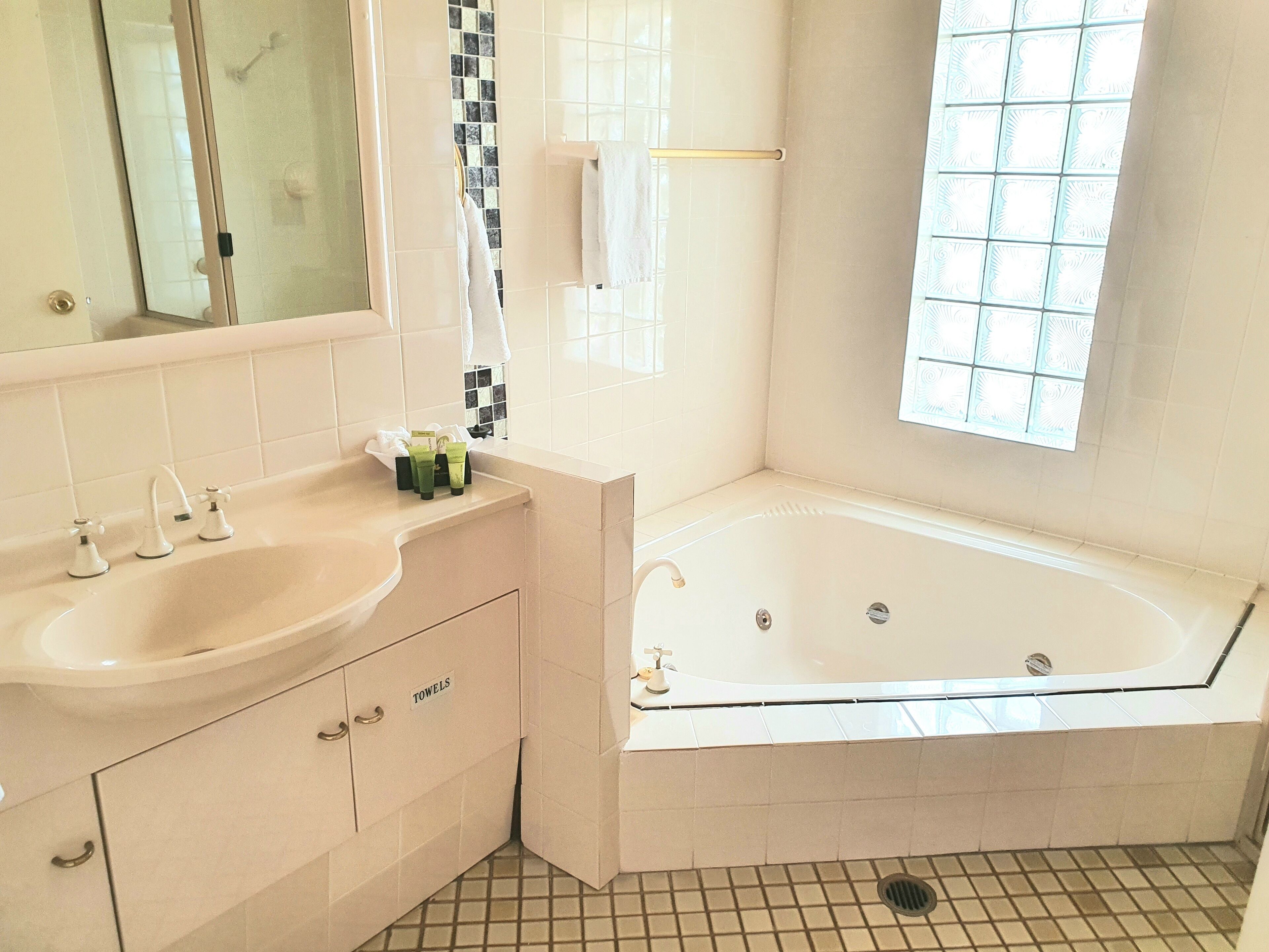 Un baño con lavamanos, espejo y bañera.