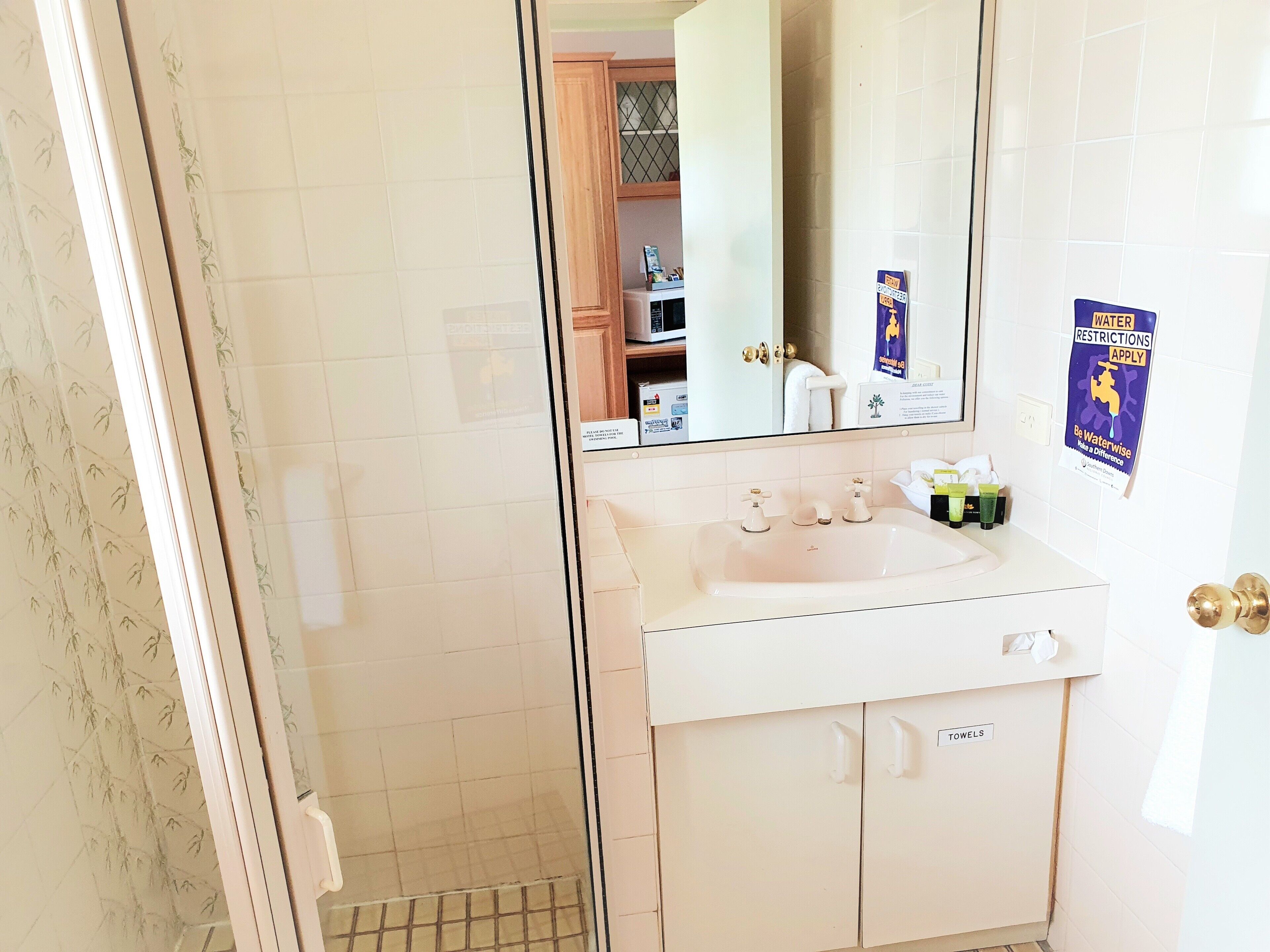 A bathroom with a white sink, a mirror, and a towel rack.