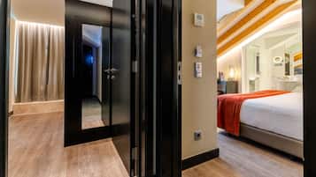 Une chambre d’hôtel avec un lit, une salle de bain avec un miroir et un plafond en bois.