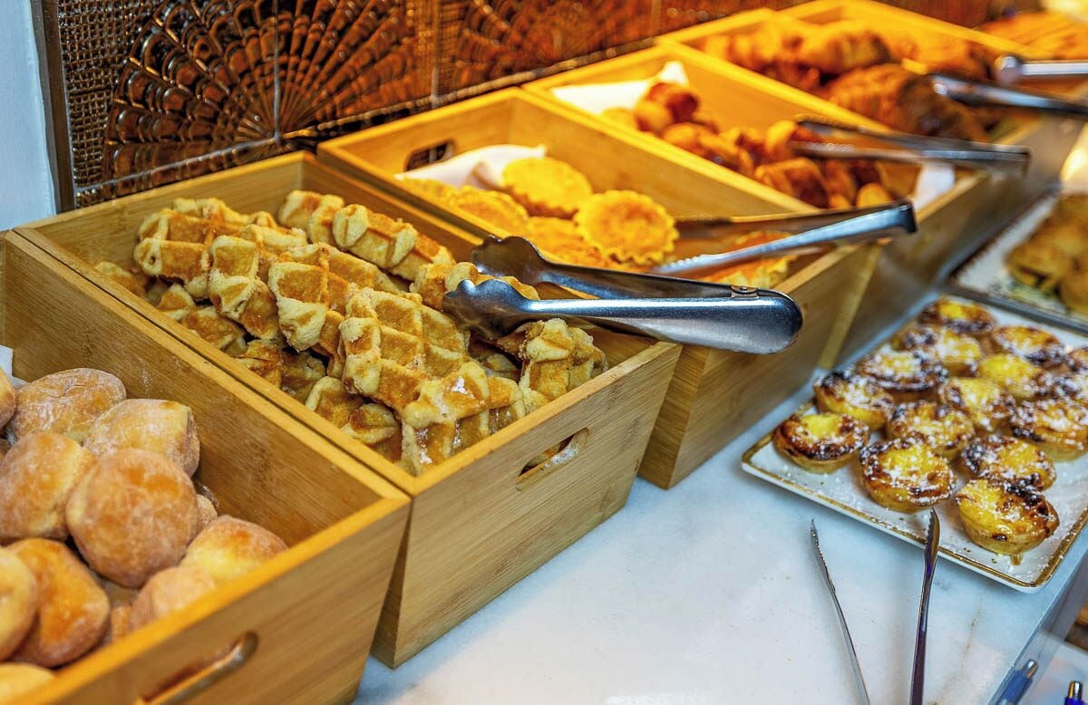 A buffet with various food items in wooden containers.