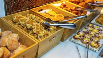 Un buffet con diversi cibi esposti in contenitori di legno.