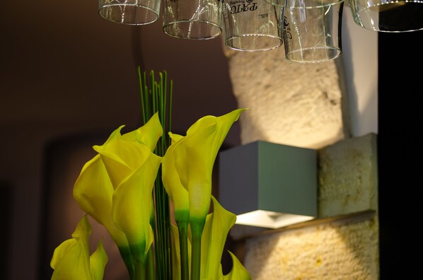 A vase with yellow flowers and a glass container with measurement markings. - Hotel Santa Justa Lisboa (Lisbon)